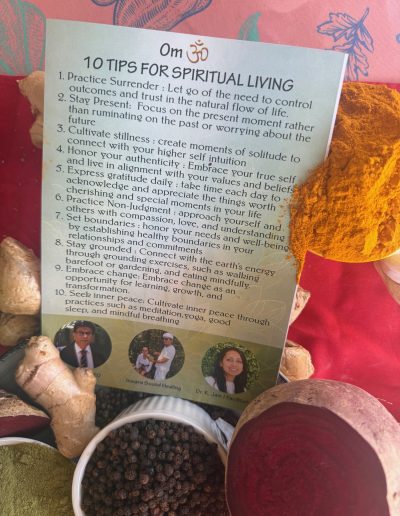 A card titled 10 Tips for Spiritual Living is surrounded by various spices, including turmeric, ginger, and black pepper—ingredients known for nutritional healing. The card lists spiritual tips and features small photos of two people at the bottom.