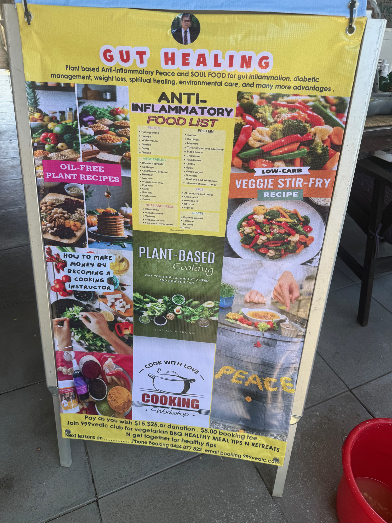 A colorful signboard titled Gut Healing advertises anti-inflammatory, plant-based food recipes, cooking instructions, and retreats. Pictures of dishes, vegetables, and cooking scenes decorate the board.